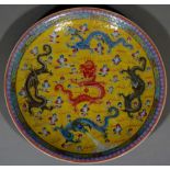 A Chinese porcelain Famille Jaune circular plate decorated with five colourful Dragons Chasing The