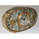 A French vintage mantel clock, the simulated grey mother of pearl oval case applied fruiting vases,