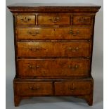 A "George I" walnut chest on stand butterfly veneered and outlined with boxwood stringing,