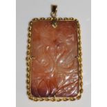A Chinese gold coloured metal mounted rectangular jade plaque pendant finely relief carved with