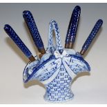 A continental porcelain fruit basket and knives, the brass blades inscribed "Uchatiusbronge",