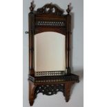 A mahogany hall wall shelf with bevelled mirror, turned cluster columns topped by vasular finials,