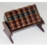 An Edwardian desk tidy shaped as six miniature books and covered wood stand,