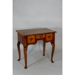 A George I style walnut veneered lowboy the rectangular top with feather and cross banded borders,