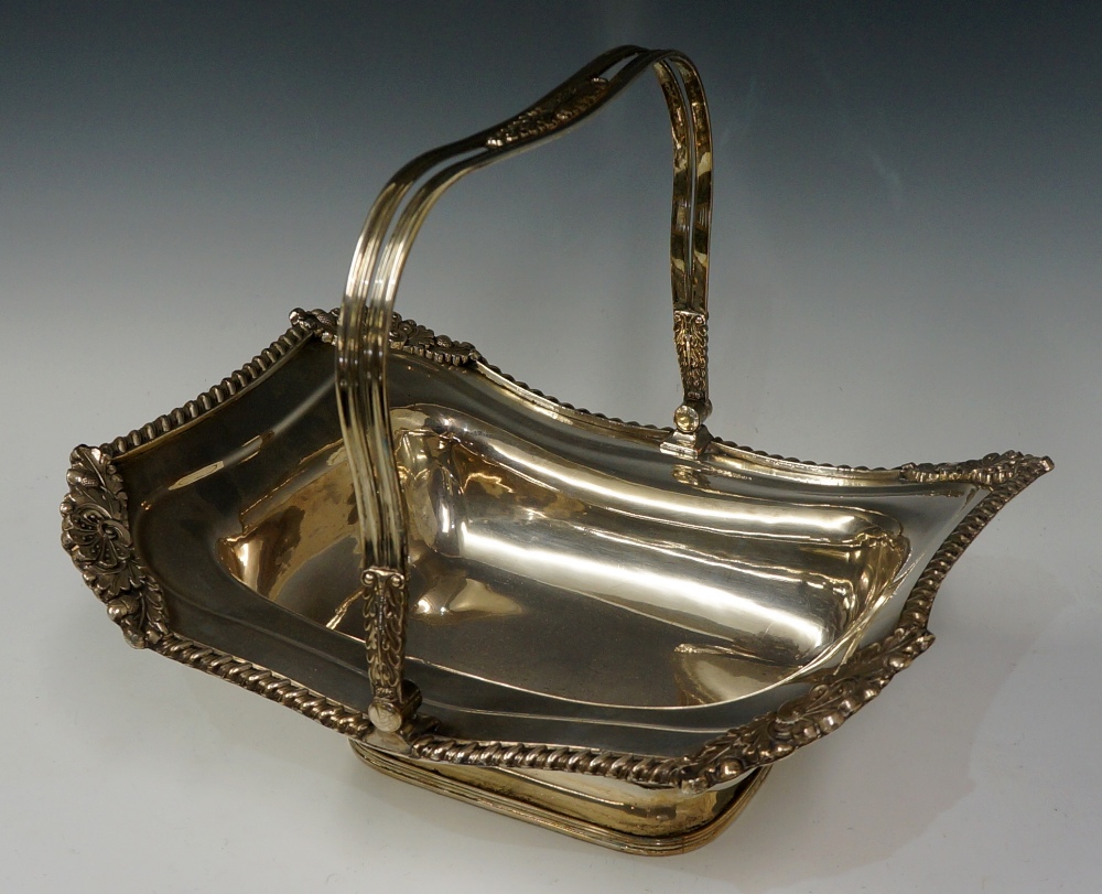 A rectangular basket with swing handle, the gadrooned border with acorn and leaf clasped corners,