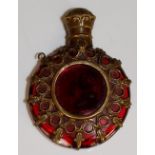 A Victorian cranberry glass scent bottle of flattened circular shape with pierced brass mounts and