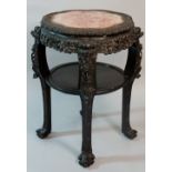 A Chinese shaped circular hardwood two tier jardinère stand with inset rosso marble top within