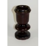 Treen - a turned mahogany candle stand with ebonised bands the cylindrical cup on bold turned