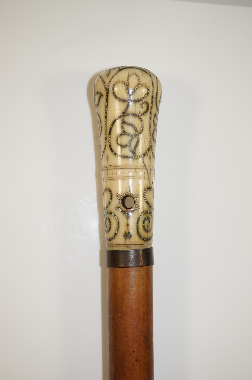 An 18th Century ivory handled piqué inlaid walking stick with stylised scrolling foliate decoration,