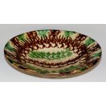 A Whieldon type circular pottery bowl with green and brown glazed decoration, shallow foot,