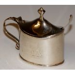 A George III navette shaped lidded mustard with reeded borders the body engraved with a crest,