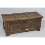 A late 17th Century oak coffer the three panel lid above a frieze carved flower heads the two panel