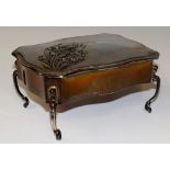 A dressing table box of serpentine outline the hinged lid embossed with iris, scrolling legs,