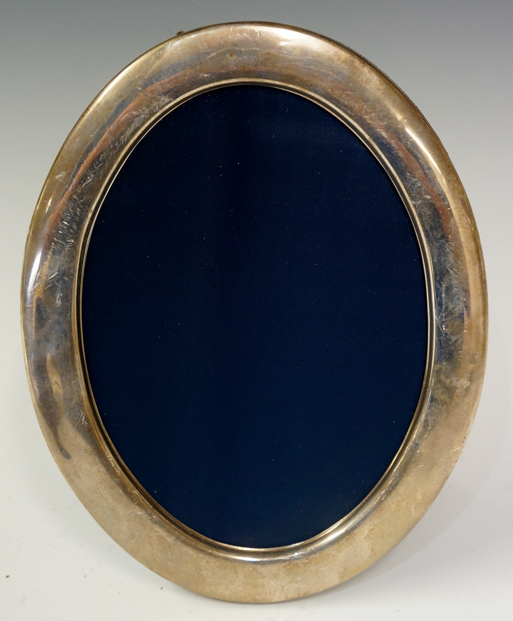 A plain oval silver photograph frame, 22.5cm high, 17.5cm wide, by R.G.