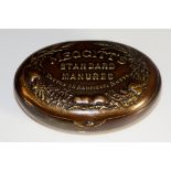 A brass hinged tin with Art Nouveau flower design on base and 'Meggitt's Standard Manures,