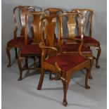 A composed set of six George I walnut dining chairs with hooped backs and vasular shaped splats,