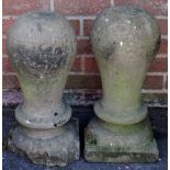A pair of sandstone tethering bitts of inverted baluster shape on square plinths,