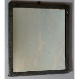 An Arts & Crafts pewter wrapped rectangular mirror the corners embossed with scrolling leafage,