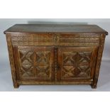 A 17th Century oak cupboard the hinged cover revealing shallow top,