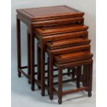 A nest of four Chinese hardwood tables with panelled rectangular tops on moulded square legs joined