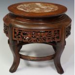 A Chinese hardwood stand the top inset with rosso marble circular panel the frieze carved with