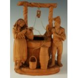 An Italian terracotta group of a couple at a well, 18cm high, impressed Made In Italy,