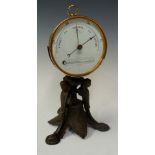 A Victorian barometer with thermometer the drum shaped brass case with white dial inscribed Stormy