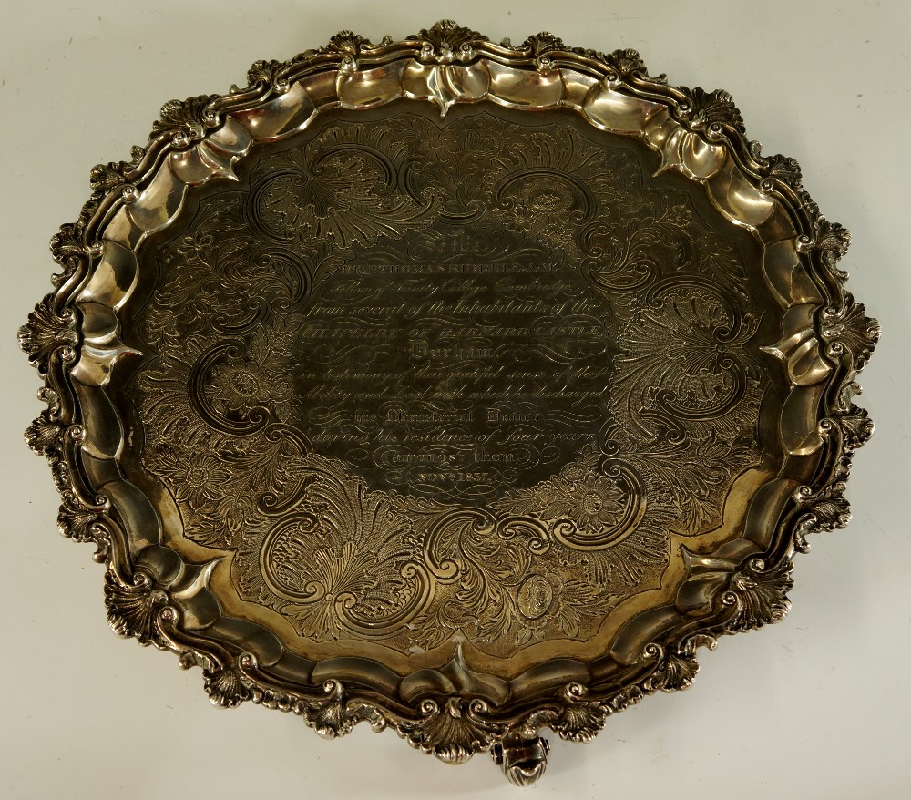 A George III shaped circular salver with leaf carved moulded border the field chased with foliate