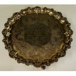 A George III shaped circular salver with leaf carved moulded border the field chased with foliate