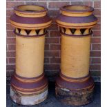 A pair of stoneware tall chimney pots of cylindrical design with heart pierced upper collars,