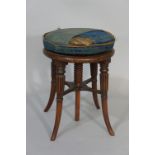 An early Victorian mahogany revolving piano stool the circular stuffed over top on a turned screw