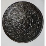 A patinated cast iron roundel cast with demi-figures, circular and oval panels of mythical battles,