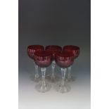 A set of five ruby bowl hock glasses, engraved with grapes and vines, clear stems, each 16cm high,
