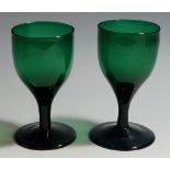 A pair of green wine glasses,