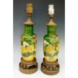 A pair of Chinese pottery lamps moulded in relief with flower heads,