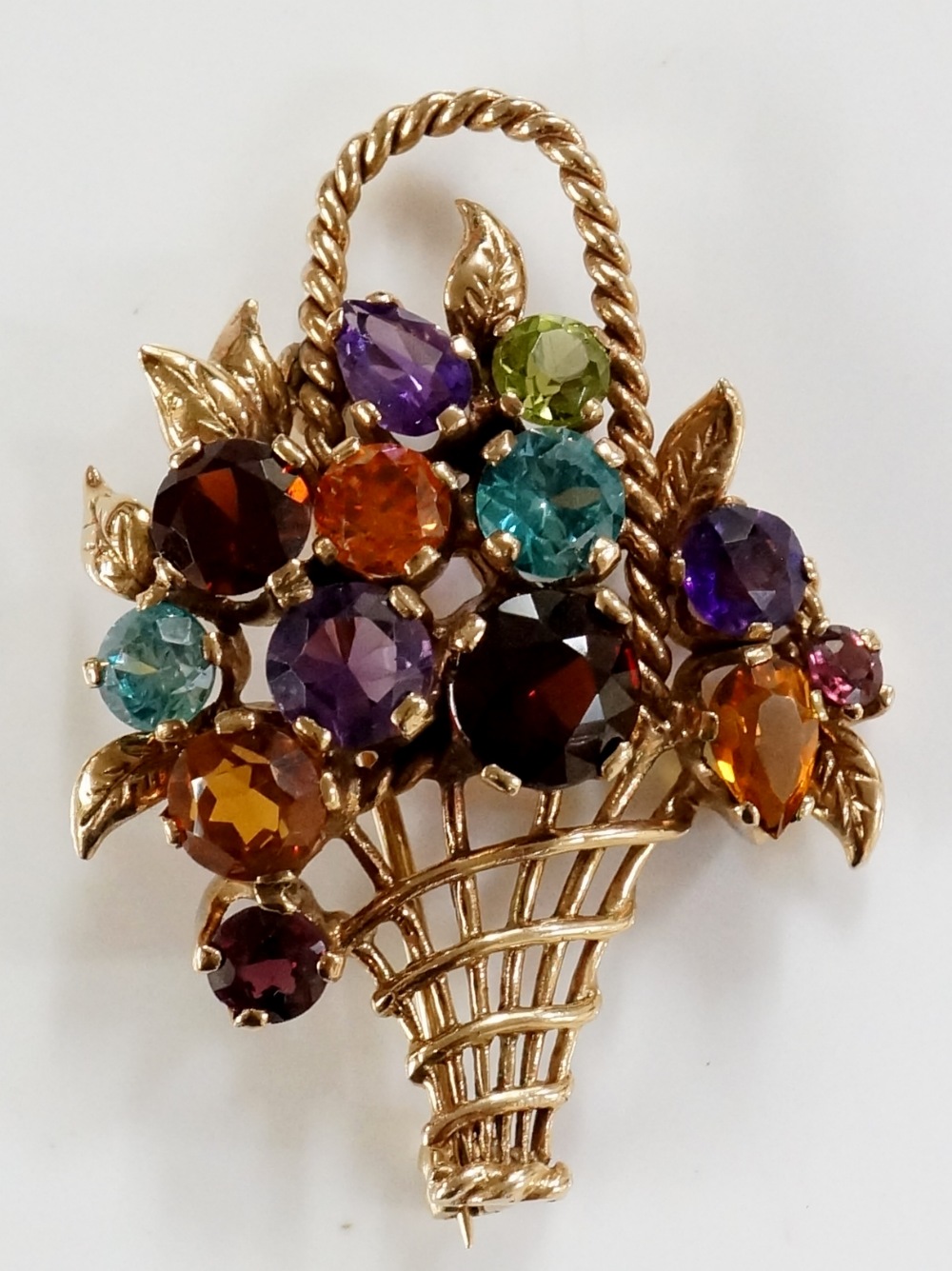 A gem set gold basket brooch, claw set with coloured stones, rope twist handle, 4.