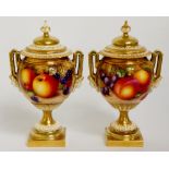 A pair of Royal Worcester two handled urnular vases one still life painted with peaches,