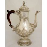 A George II pear-shaped coffee pot, the hinged lid with wrythen fluted finial, above a body chased