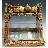 An unusual fish tank, cuboid, open topped glass bowl with plaster base and surround,