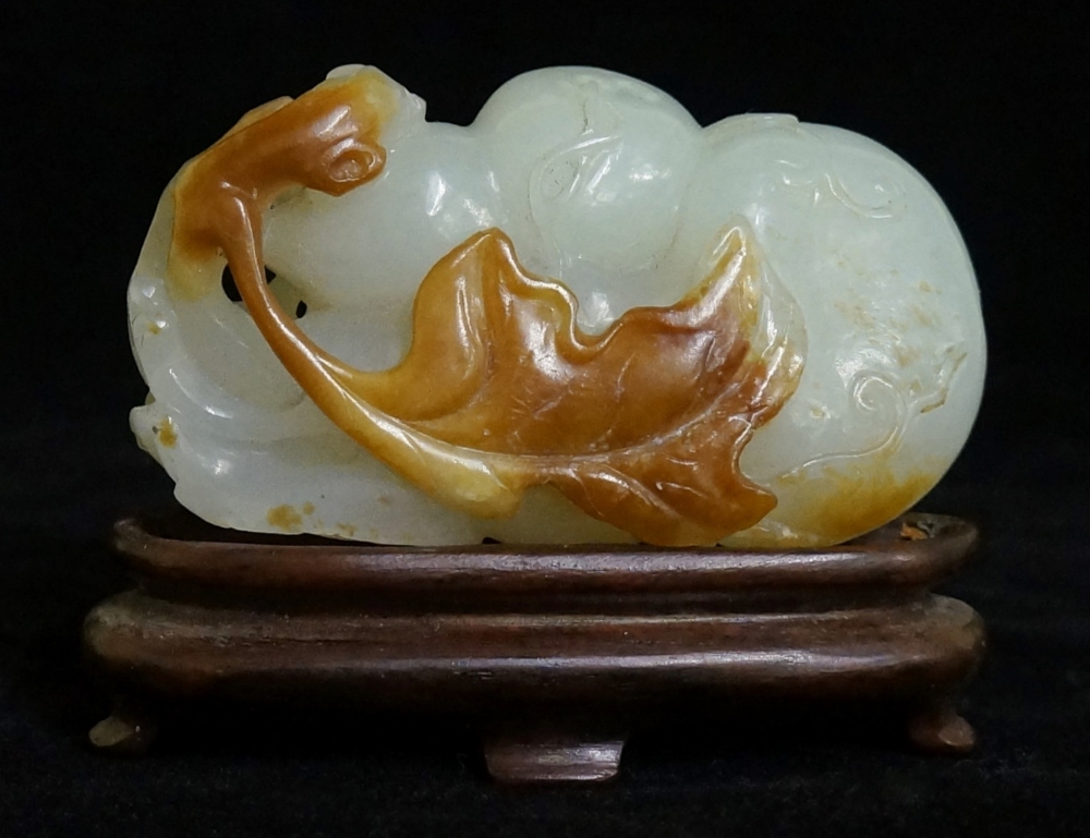 A pale celadon jadeite group carved as fruit, trailing vines and leafage,