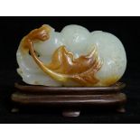 A pale celadon jadeite group carved as fruit, trailing vines and leafage,