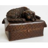 A Black Forest snuff box, the hinged lid carved with a dog sleeping on a tasseled cushion, 10.