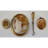 A shell cameo brooch depicting lady with arm raised for bird to perch upon,