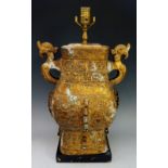 A gold painted metal Chinese style lamp base of archaic form, black rectangular wooden base,