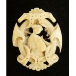 A fine Victorian carved ivory brooch of shaped oval design the centre finely carved with a female