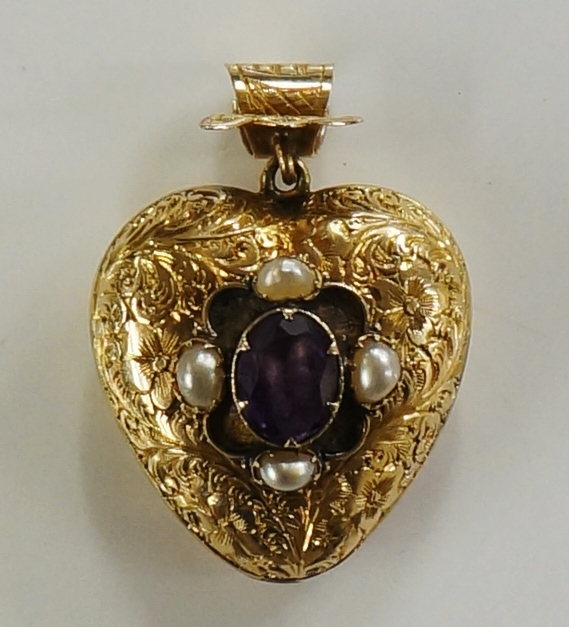 A Victorian foliate engraved heart shaped locket the centre with oval claw set amethyst within four