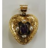 A Victorian foliate engraved heart shaped locket the centre with oval claw set amethyst within four