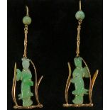 A pair of jadeite and gold earrings carved with female figures within stylised leafy frame,