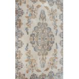 A large Persian Kashan carpet worked with blue and yellow central medallion on a cream ground,