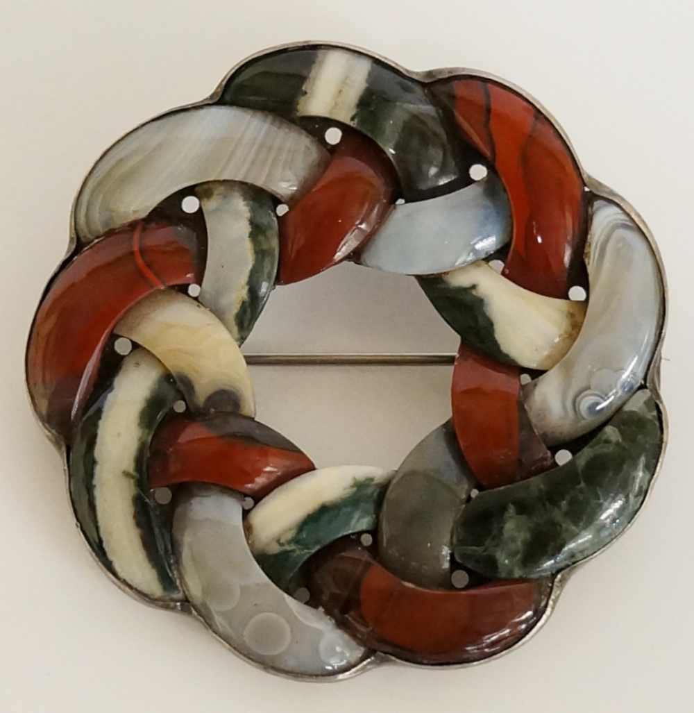 A Scottish hardstone brooch of shaped circular design modelled as interlaced hardstones,